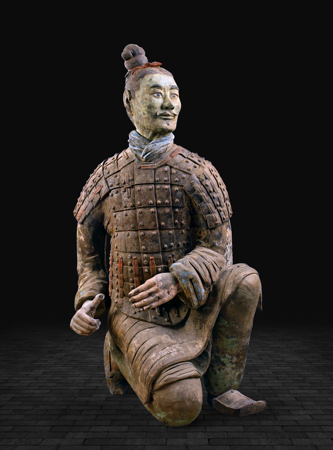 跪射武士俑出土于秦兵马俑二号坑东端的弩兵阵中心,它们身穿战袍,外披