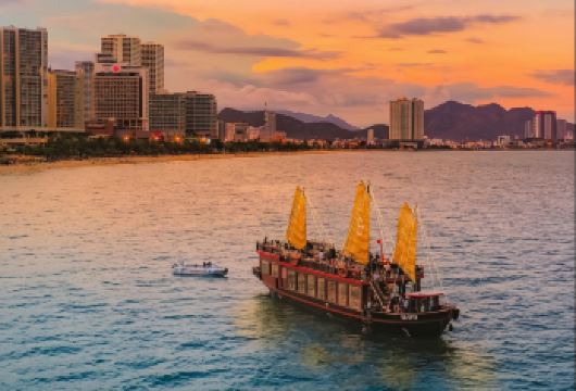 芽庄帝王豪华日落游船之旅 - 豪华套餐【享受芽庄湾的豪华日落巡航之旅，从欢迎饮品开始，沿途欣赏令人叹为观止的海岸线美景。 在星空、月光与璀璨城市天际线的映衬下，一边享用船上供应的五道式海鲜晚餐，一边欣赏现场音乐演奏。 在日光甲板或休息室享用鸡尾酒放松身心，随后返回港口并舒适地转乘至您的酒店。】