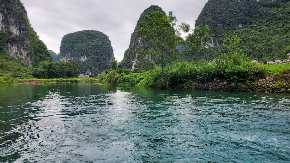 从水面看吞榜天窗周边的山峰与岸边绿植。