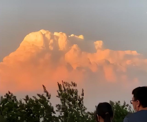 北京傍晚时分天空出现火山式晚霞，流云翻滚吸引路人驻足观看