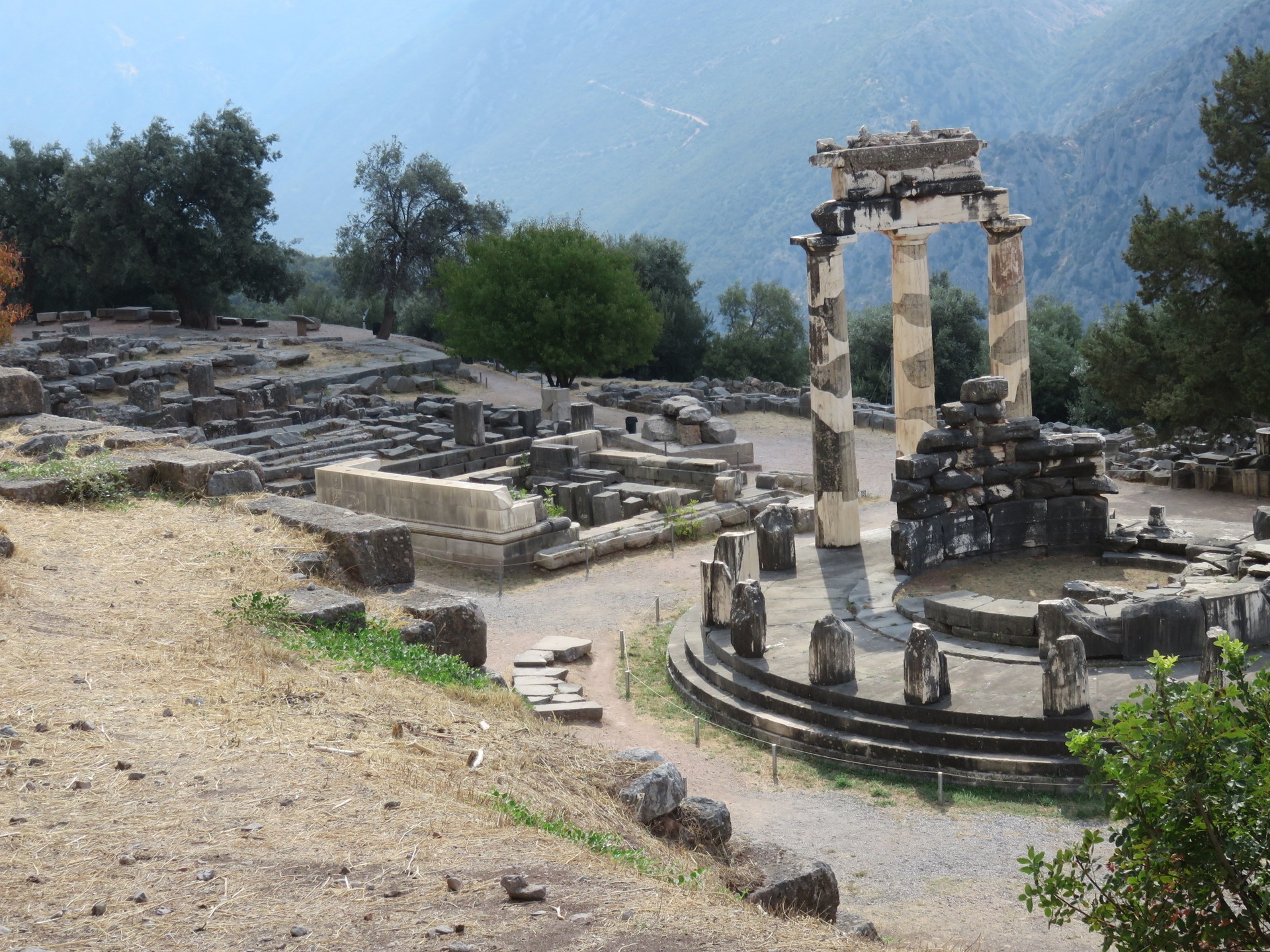 #城市人文手记 德尔菲古遗址位于雅典西北方帕尔纳索斯山麓，因居于该地的德尔菲族人而得名。它始建于公元