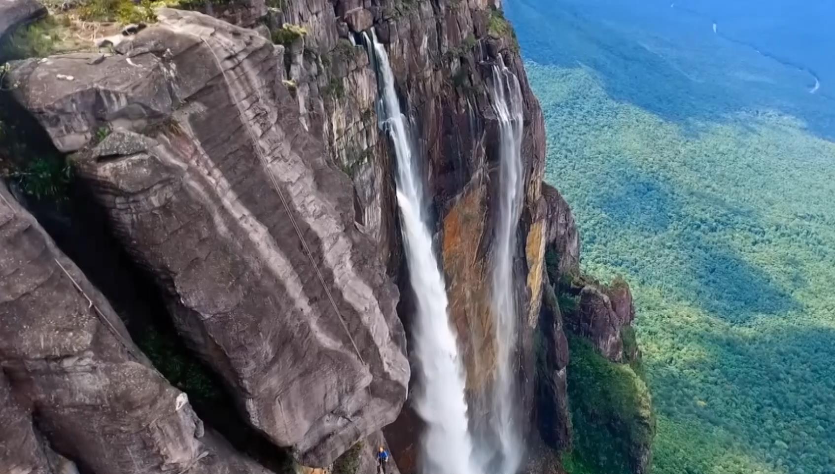 九百多米的悬崖瀑布，竟然有人在旁边攀岩