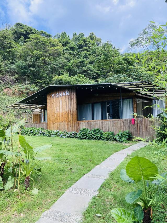 Wooden cottage at Yishan Tea Garden Homestay surrounded by forest