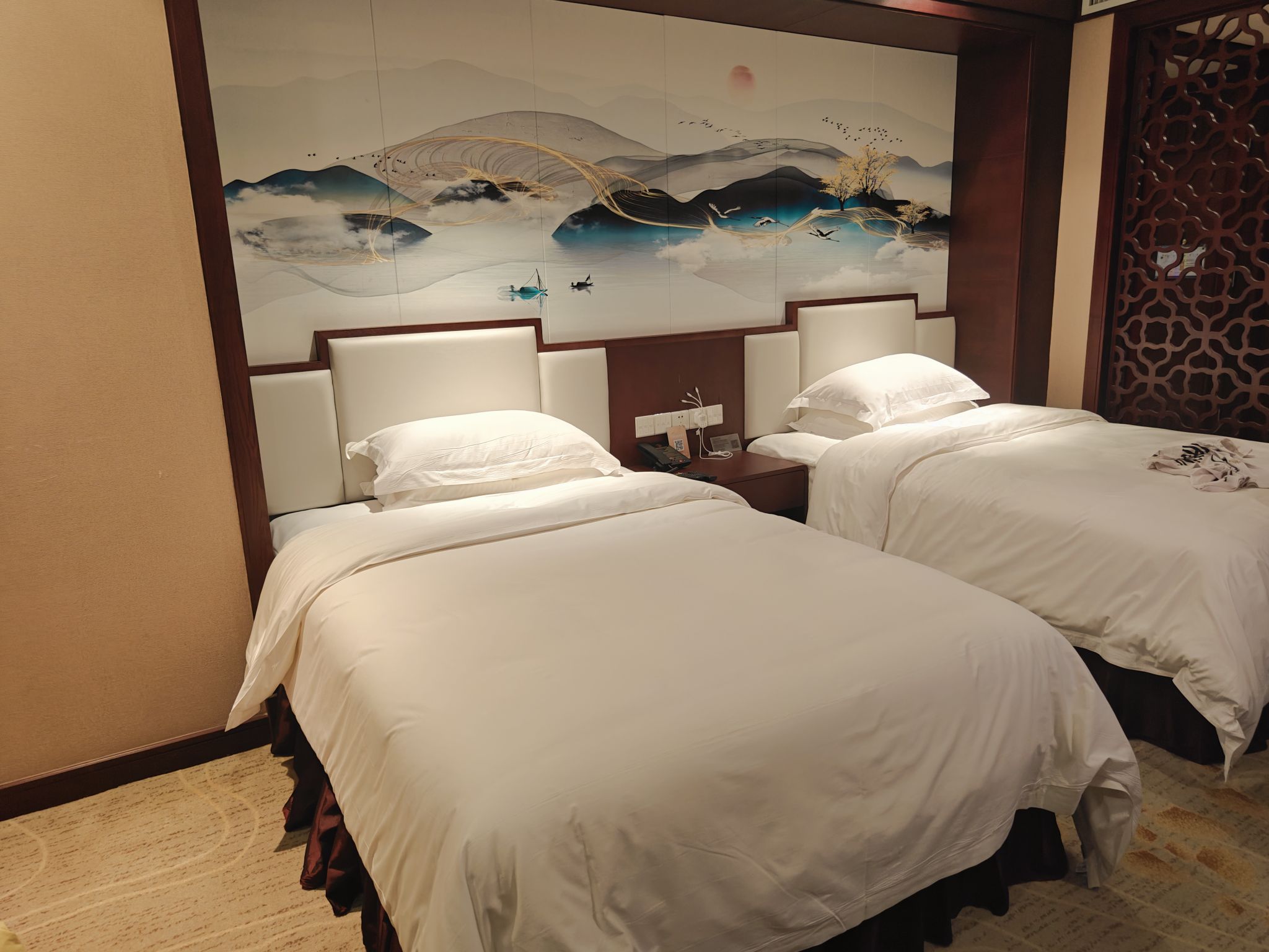 这家酒店的房间设计精心融合了现代舒适性与东方传统美学。床铺整洁，配以高品质的床上用品，确保了住客的睡