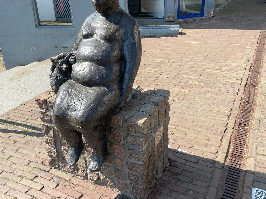 Beeld van zittende vrouw met hond in tas