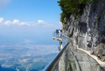 张家界中国团队游：天门山国家森林公园（VIP快速通道）【体验一段移动的“风景走廊”，从城市景观一路向上，进入一个梦幻般的深谷和雾气缭绕的森林世界。 惊叹于其核心景点——一座贯穿山体的巨大天然拱门，它常常笼罩在神秘的云雾和阳光之中。】