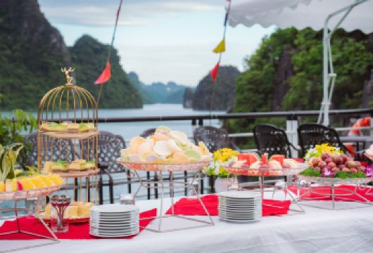 下龙湾6小时豪华游船一日游（惊讶洞 – 蒂托普岛 – 皮划艇）【乘坐6小时豪华游轮探索下龙湾，参观惊讶洞和蒂托普岛。 您可以划皮划艇或乘坐竹筏游览卢昂洞穴风景秀丽的泻湖。 在游轮穿梭于石灰岩山脉之间时，尽情享用船上的越南籍午餐和日落派对。】