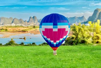 阳朔私人一日游：热气球飞行、竹筏漂流与龙舞表演【乘坐热气球静静翱翔于阳朔上空，俯瞰漓江蜿蜒流淌于连绵不绝的喀斯特峰林间，将令人屏息的壮丽全景尽收眼底。 在玉龙桥下体验活力四射的金龙舟巡游，感受当地鼓乐与民俗仪式的澎湃激情。 乘一叶宁静的遇龙河竹筏漂流，近距离探索令人惊叹的喀斯特地貌。】