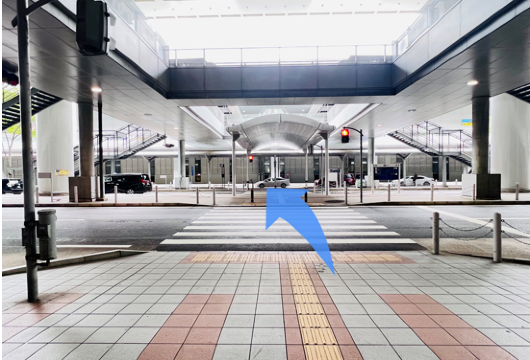 2つの横断歩道を渡った後、左折してシャトル乗り場へ向かう