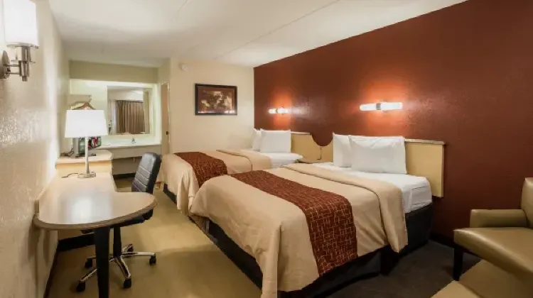 Cozy hotel room with two beds, table and chairs at Red Roof Inn Indianapolis South