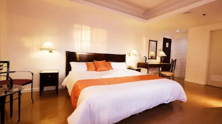 Spacious hotel room with large bed, table and chairs at Harbor Town Hotel