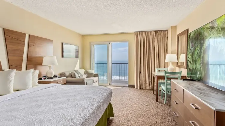 Hotel room decorated in warm colors with sea view at Americana Hotel Boardwalk