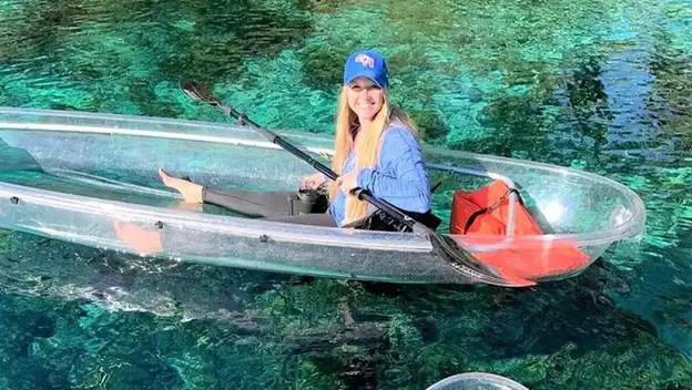 Smiling woman in a glass-bottom kayak