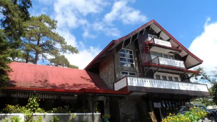 Retro hotel building exterior under blue sky at Log Cabin Hotel - Safari Lodge Baguio