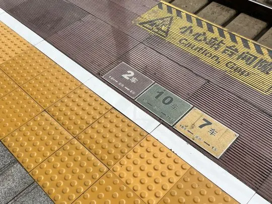 中国高速鉄道のプラットフォーム。足元に車両番号の表示と黄色い点字ブロック、「注意安全ライン」の案内がある。
