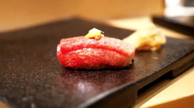 At Sushi Hirokawa, guests are seated at counter seats where the chefs craft the dishes right before their eyes.