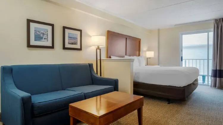 Modern hotel room with bed, sofa and coffee table at Comfort Inn Ocean City Boardwalk