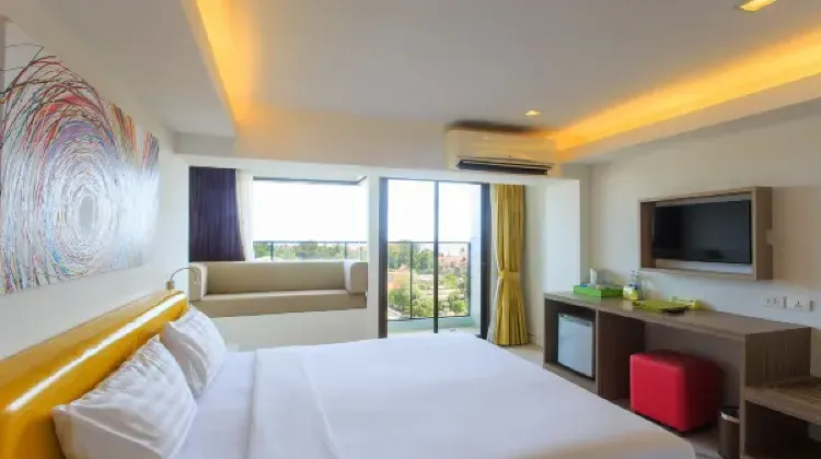 Bright hotel room with bed, table, chairs, TV at Samui Verticolor