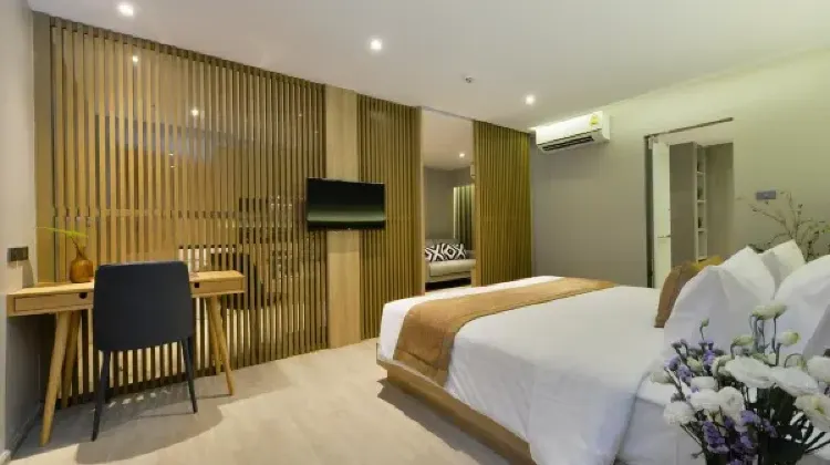 Hotel room with bed, table and chairs at Studio Ekamai