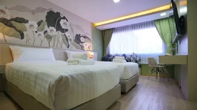 Cozy hotel room with two beds, table and chairs at The Qube Fifty Hotel