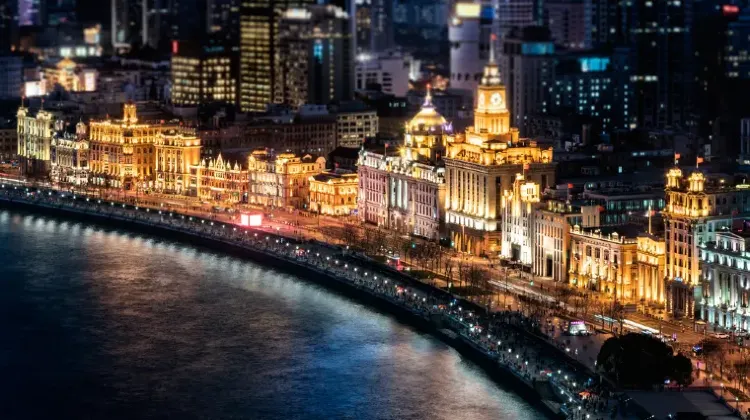 夜の上海・外灘の風景。黄浦江の水面に街の光が映り込み、ライトアップされた歴史建築が並ぶ美しい夜景。