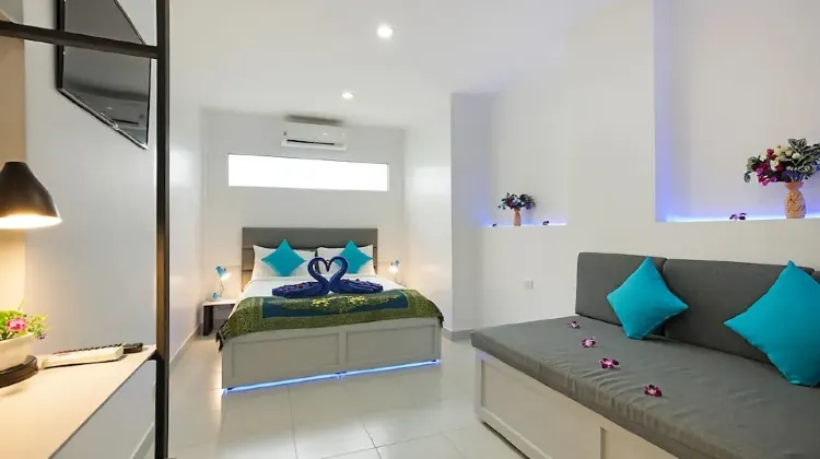 Neat hotel room with sofa, bed and table at Colorize Boutique Hotel