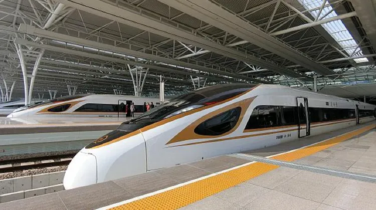 中国高速鉄道のプラットフォームに並ぶCRH列車。白と金の車体が特徴で、近代的な屋根の下に停車している様子。