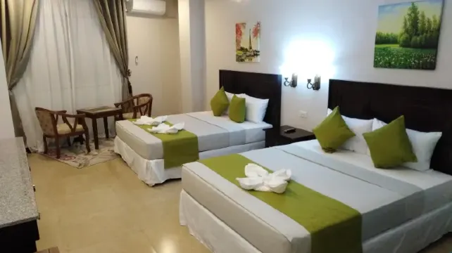 Bright hotel room with two beds, table and chairs at Venezia Suites Hotel Iloilo