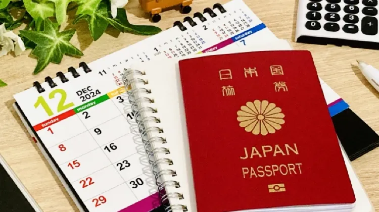 日本のパスポートとスケジュール帳、2024年12月のカレンダー。海外旅行の計画や出発準備をイメージした写真。