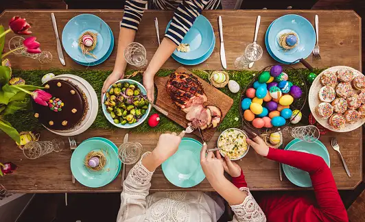 Easter Table with cakes, cooked ham, boiled eggs, and other foods