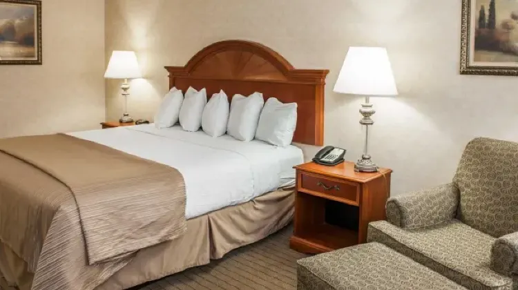Comfortable hotel room with bed and sofa chair at Quality Inn Indianapolis