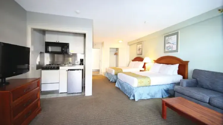Bright hotel room with sofa, bed and TV at Flagship Oceanfront
