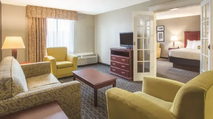 Hotel room with spacious living room and cozy bedroom at La Quinta Inn & Suites by Wyndham Indianapolis South