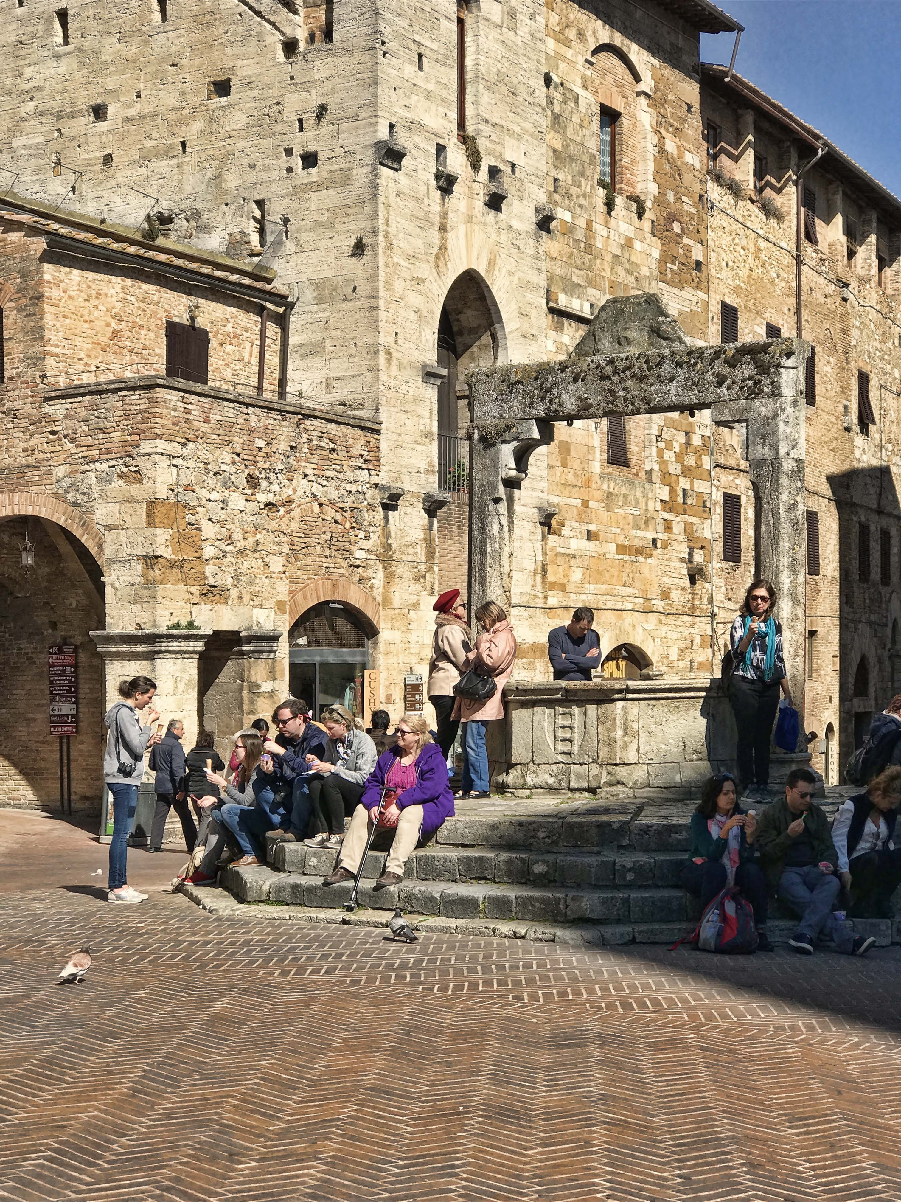 我们在水井广场（Piazza della Cisterna）上的古老水井旁边坐下，同时欣赏美味和古城