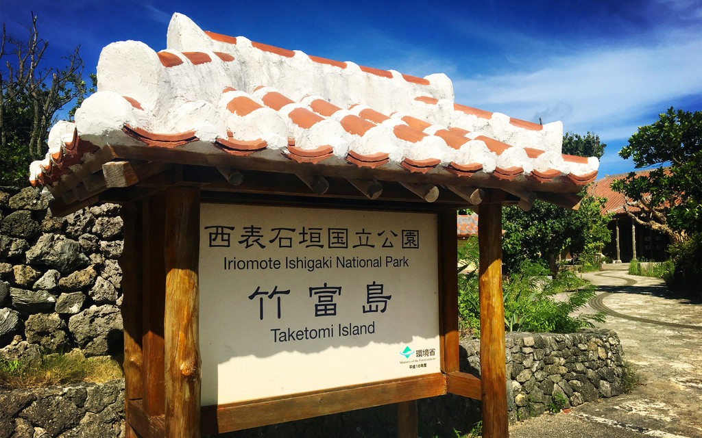 竹富岛保留了早期冲绳的样貌，满是红瓦屋顶的木房子，围墙以石头堆砌而成，白砂道路很容易风吹扬尘，岛上要