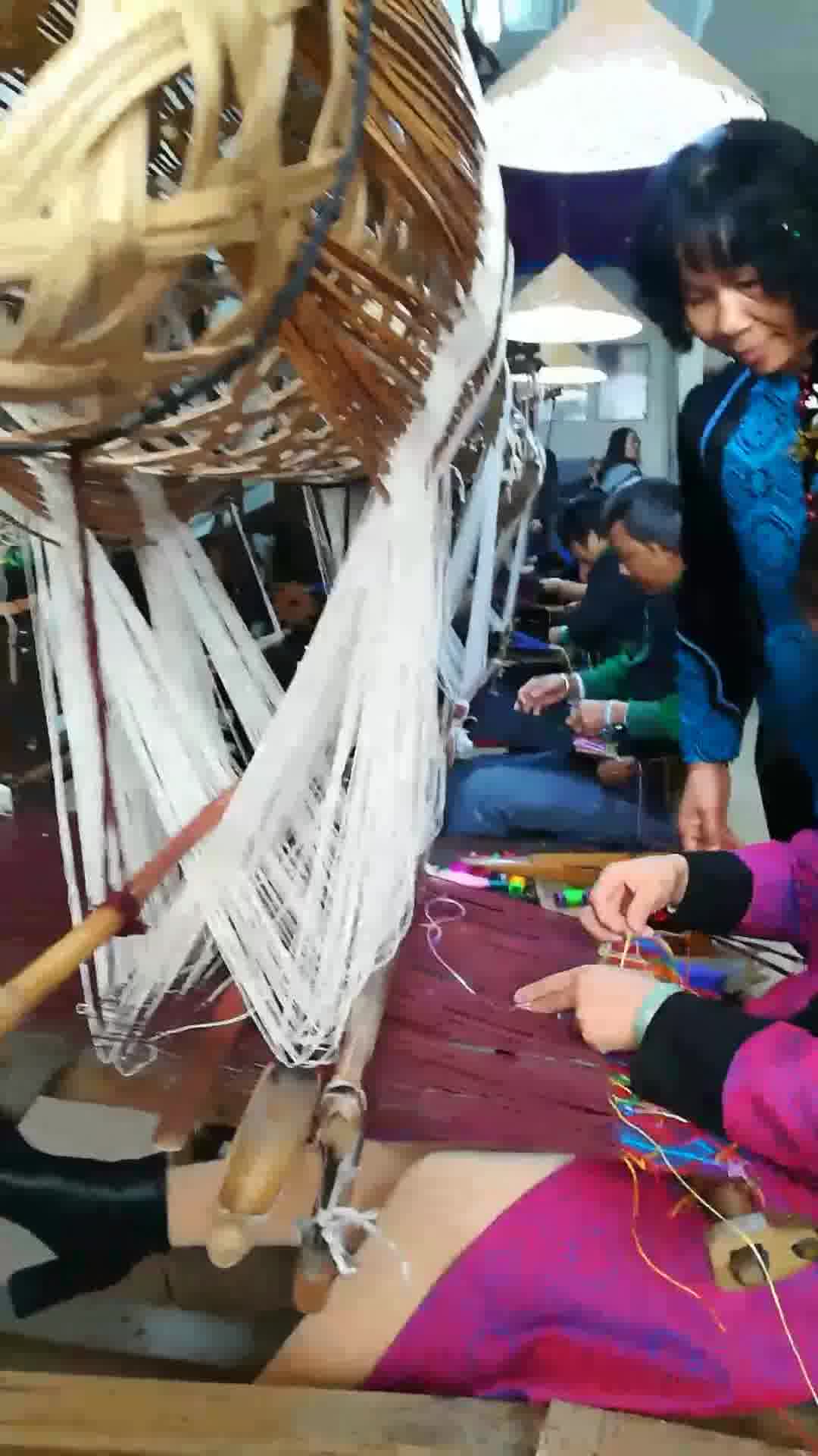 工艺大师谭湘光指导农民工用传统的竹笼机织壮锦
