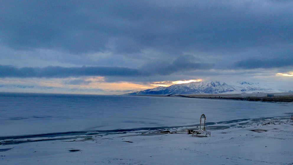 赛里木湖等日出🌄 美丽的赛里木湖依然被雪覆盖着，清晨的一缕晨光，显得湖面宁静而洁白，寒风中，冷的人瑟
