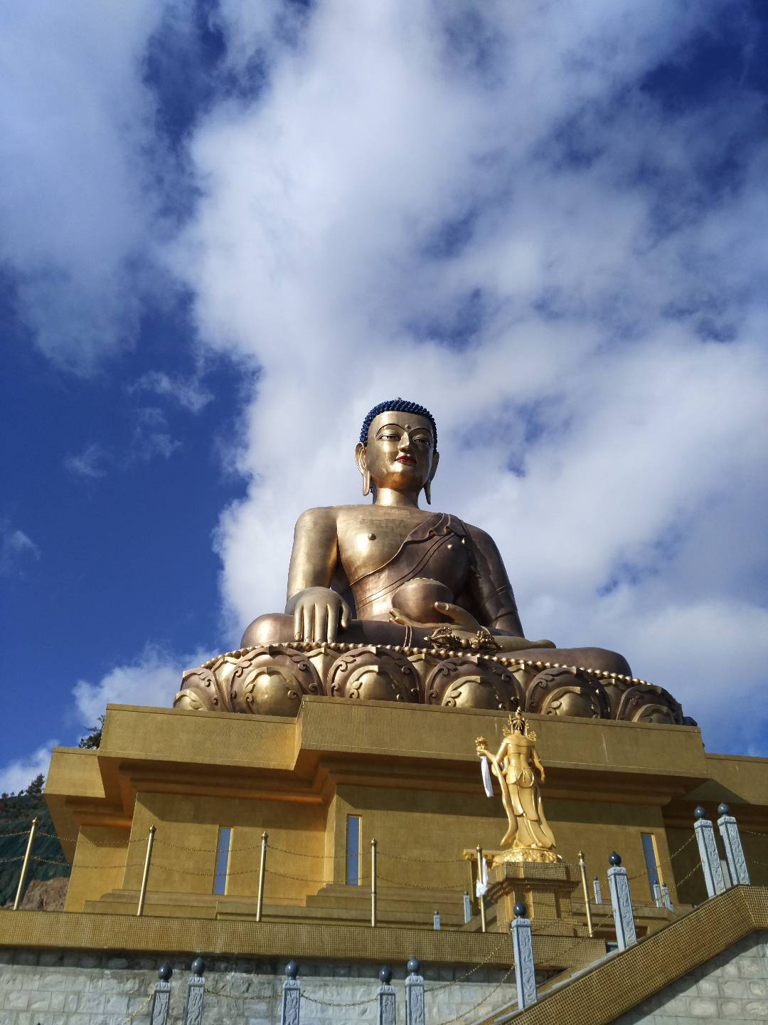 #大美不丹#👀  廷布•大坐佛，由32尊天女像围绕，仿佛从天而降，与雪山、蓝天、白云浑然一体，俯瞰整