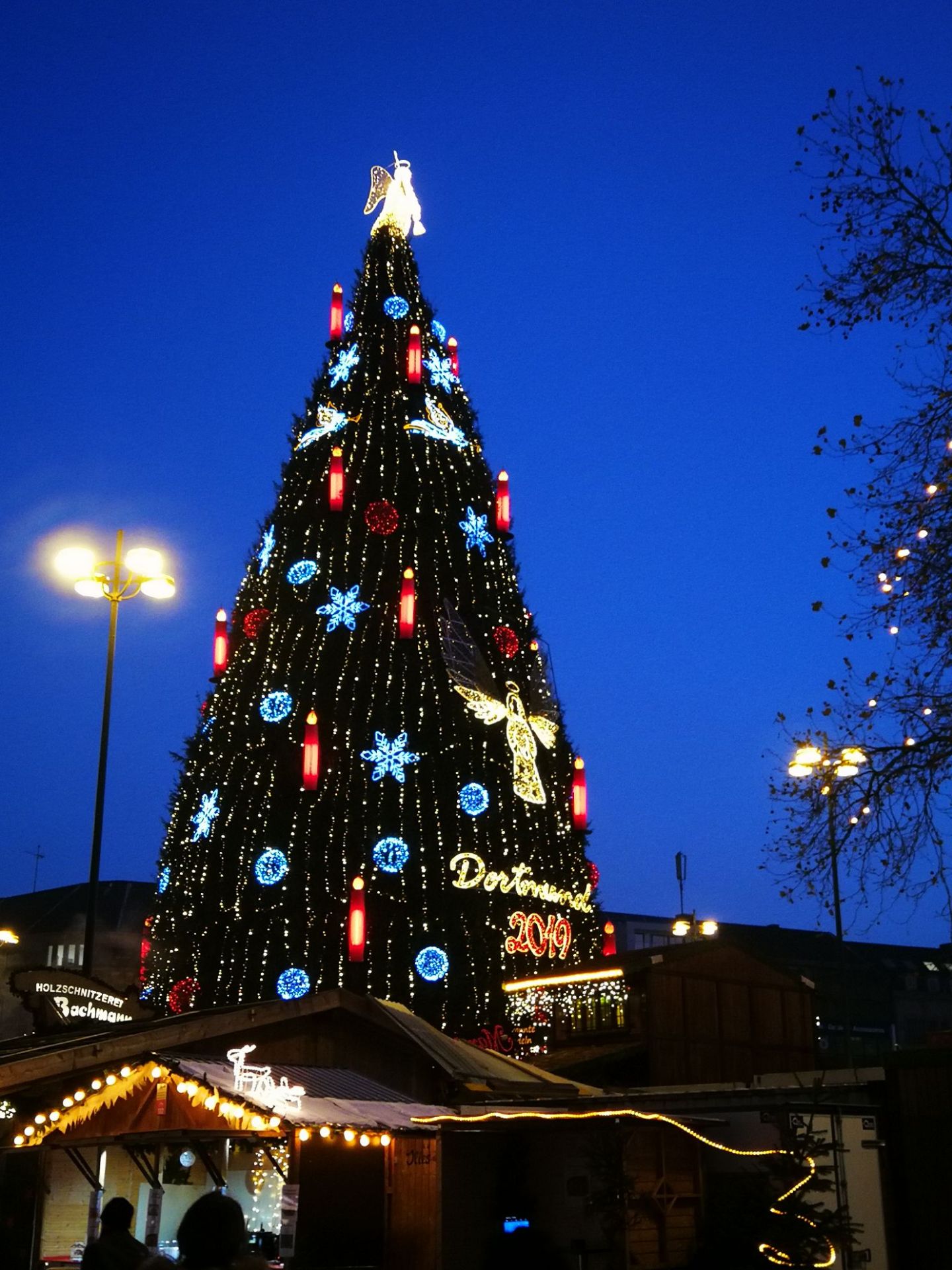 这里是多特蒙德的圣诞市场上的，人很多，高大的圣诞树🎄屹立在小广场上，市场里，以吃为主，很多种类，也有