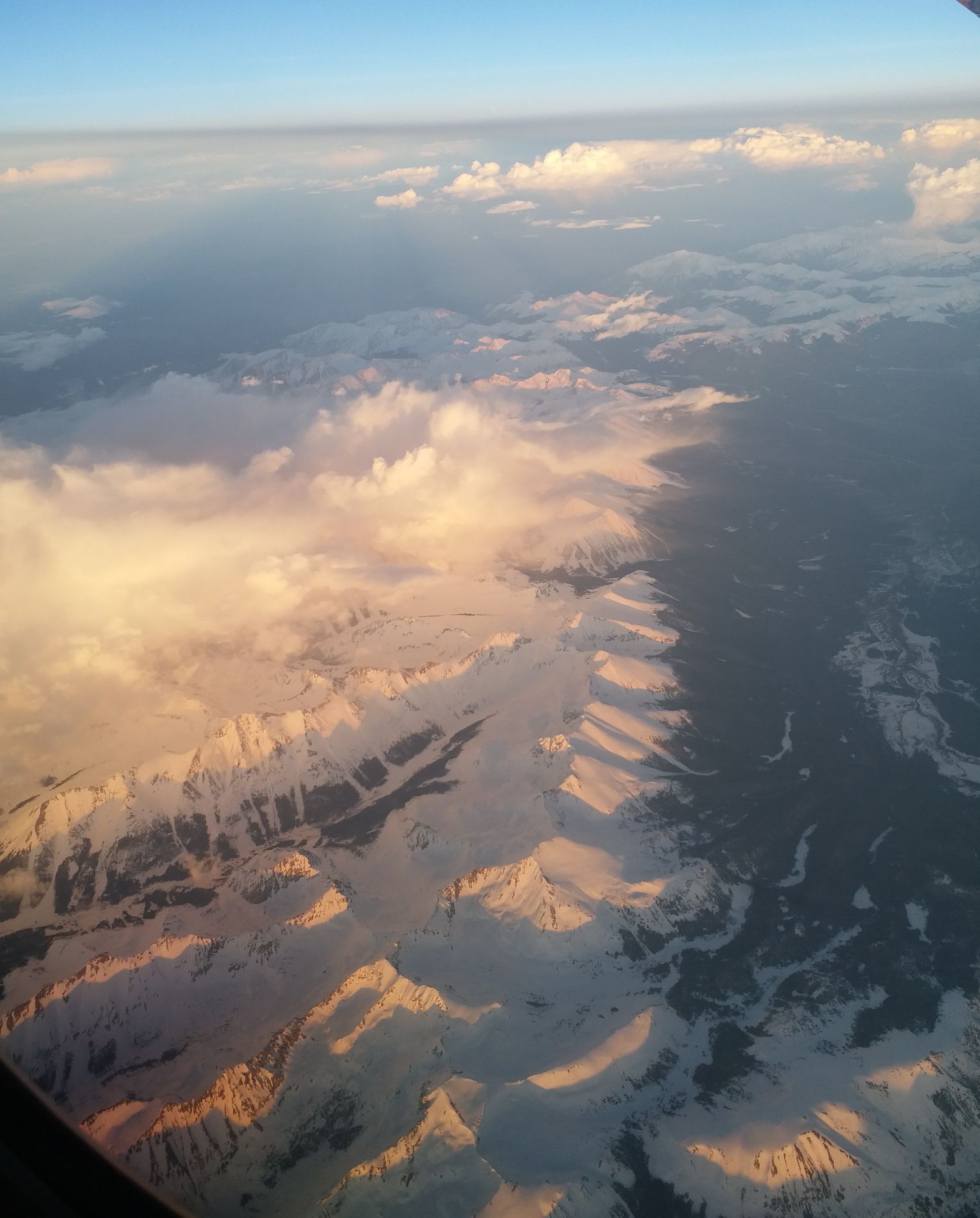 空中拍摄落基山山脉。雪山霞光很美。
