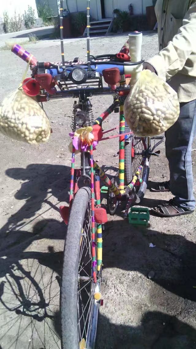 卖花生的小贩，自行车装饰得很漂亮。在当地村子里，有辆自行车就是富户了。