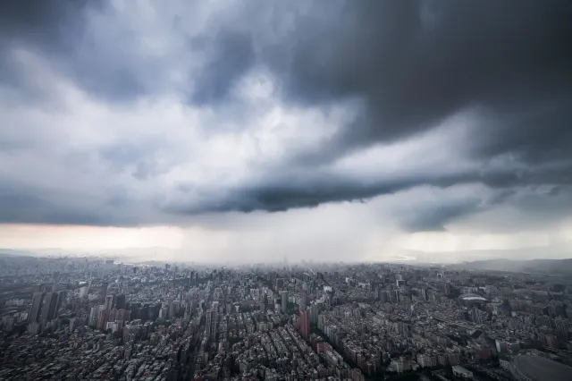 颱風外圍環流影響下，台北市區上空布滿厚重烏雲並降下豪雨