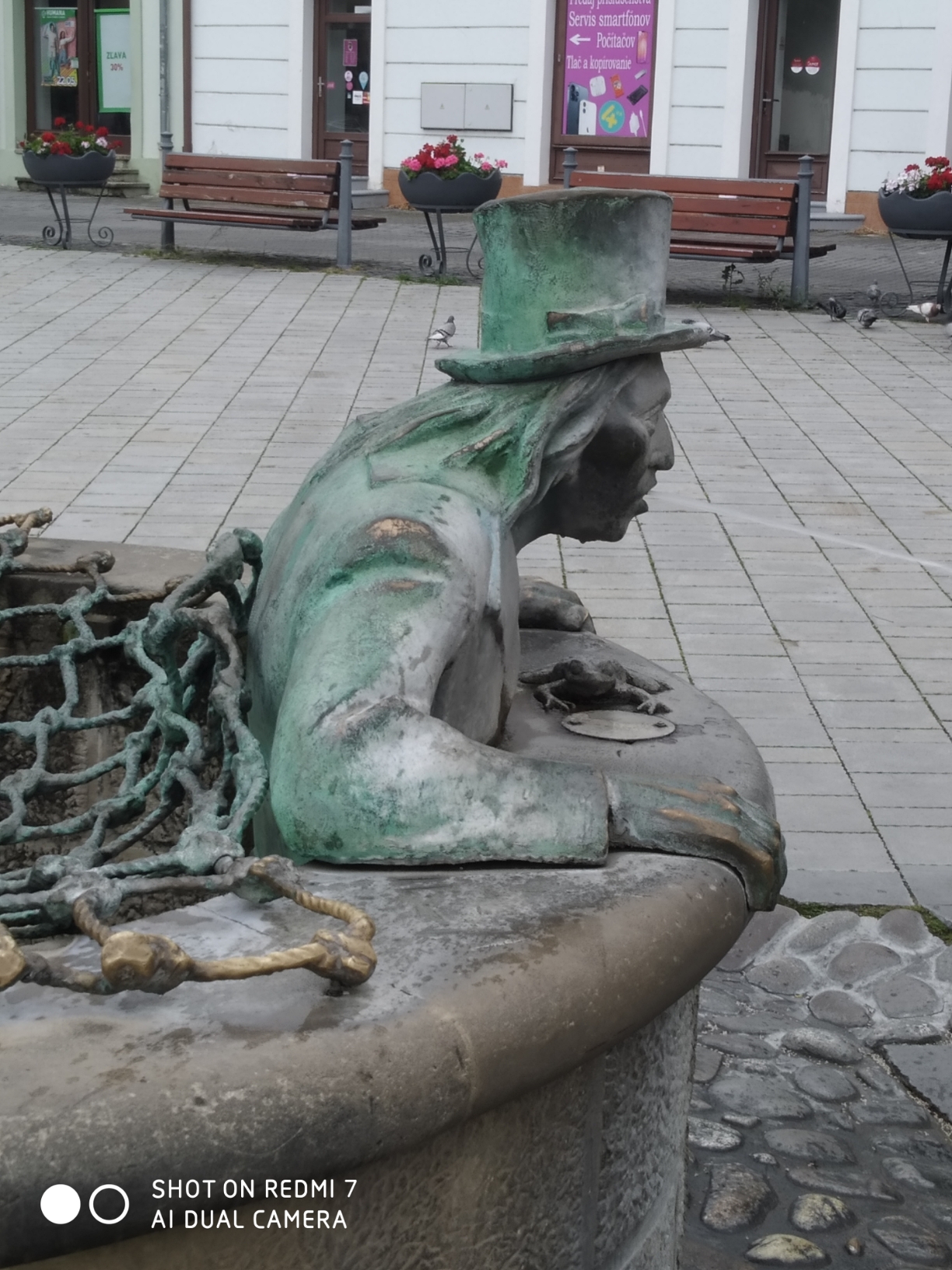 特伦欽老城街头，一个废弃水井网盖的铜雕像。