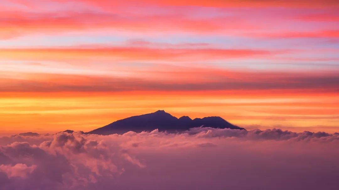 看云海在山间涌动，等待日出将远处的火山照亮｜爪哇岛