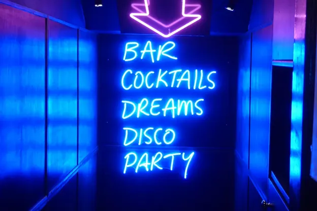 Neon blue sign saying bar, cocktails, dreams