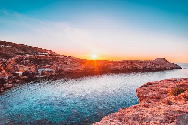 The sun setting over coves in Ibiza